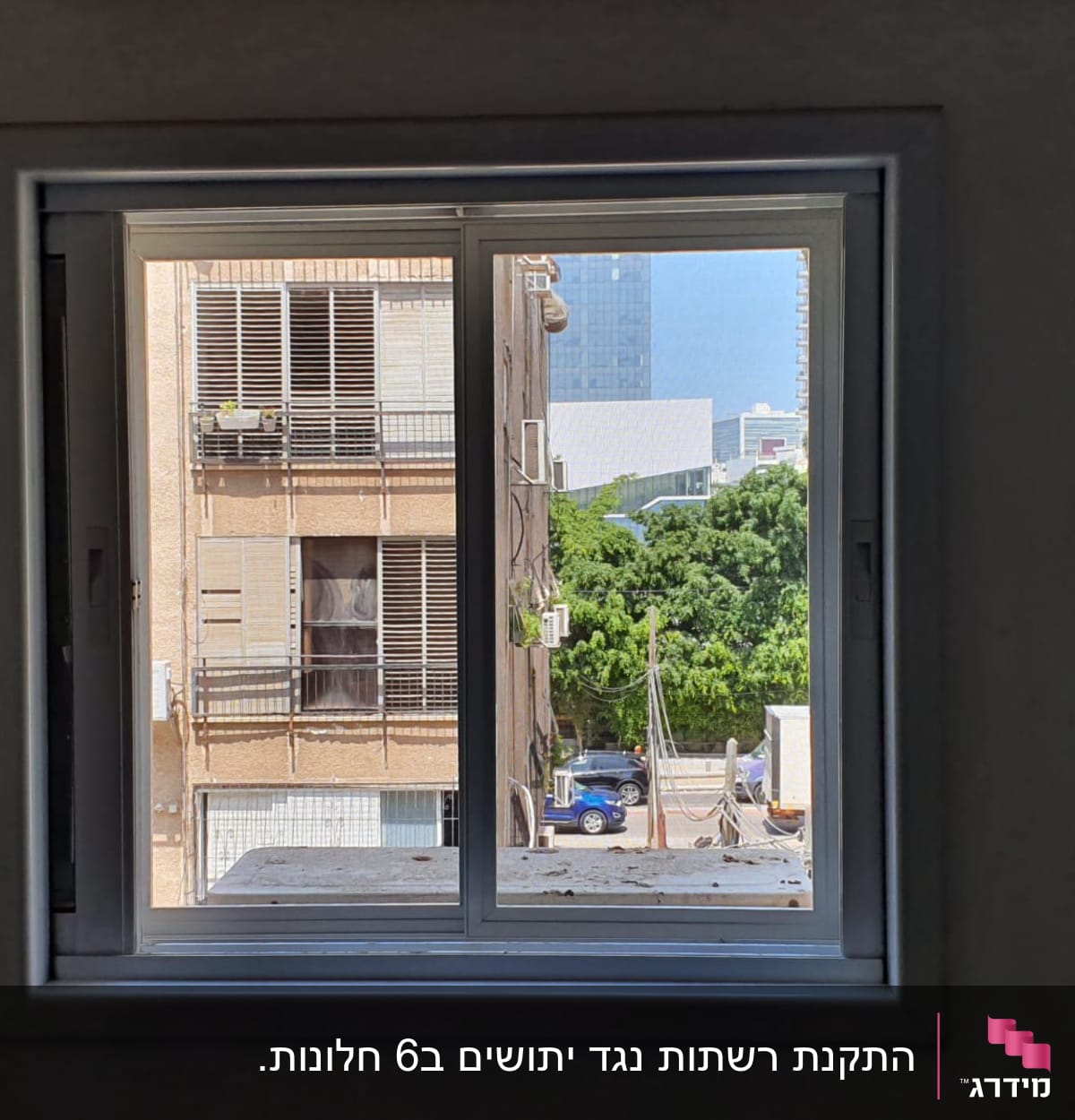 חלון אלומיניום עם נוף עירוני ברקע